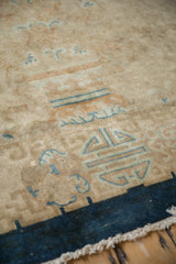 Low pile and knot heads of an antique Art Deco carpet with geometric blue border details.