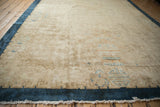 Low angle view of an antique Art Deco carpet highlighting the tone-on-tone beige field and cobalt border.