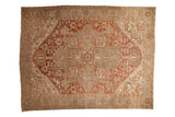 A vintage distressed Heriz carpet with a geometric medallion in dusty brick red, terra cotta, and platinum.