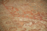 Time-softened pile of a distressed Persian Heriz rug showing visible knot heads and geometric patterns.