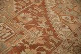 Low pile and worn texture of a vintage Heriz rug with geometric floral motifs.