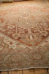 A low-angle view across the vintage Heriz carpet's worn, textured pile and geometric pattern.