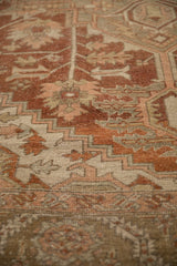 Worn pile and hand-knotted weave of a vintage Heriz carpet with terra cotta geometric details.