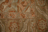 Close-up of the distressed Heriz rug's serrated leaf border with a worn, low-pile texture.