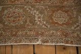 Worn, hand-knotted pile and secured side selvage of a vintage distressed Heriz carpet.