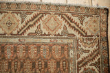 Corner detail of a vintage Hamadan rug showing the serrated leaf border and lightning contour.