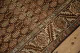 Boteh patterns in coffee brown and pale blue alongside a serrated leaf and floral main border.