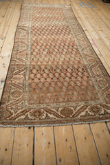 Full perspective of a vintage Hamadan runner showing its distressed texture and repeating boteh pattern.