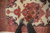 Detailed view of antique Fereghan rug's ivory ground, central medallion, and visible pile wear.