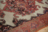 Antique Fereghan rug with visible wear on tomato red border and navy corner spandrel.