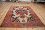 Antique Fereghan rug corner showing tomato red border, sapphire blue spandrel, and ivory fringe.