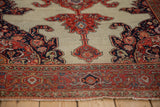 Worn texture of a Persian Fereghan rug's tomato red border and ivory spandrel.