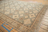 Angled view across the abrashed field of a distressed Sivas carpet with repeating geometric medallions.
