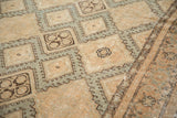 Angled detail of a distressed Sivas carpet showing the worn texture and hook-and-latch medallion design.