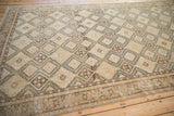 Angled view of a vintage Sivas carpet's full geometric pattern and distressed texture.