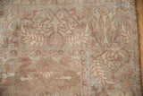 Low pile texture and serrated leaf motifs on the corner of a distressed antique Sultanabad carpet.