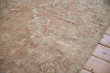 Distressed texture of an antique Sultanabad rug showing worn pile and serrated leaf designs.