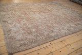 Angled view of a distressed Sultanabad carpet's muted serrated leaf designs and time-softened texture.