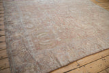 Antique Sultanabad carpet viewed from a long angle, showing its distressed, time-softened floral pattern.