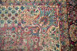 Antique Kerman carpet detail: dense floral bouquets and meandering vines on ivory field.