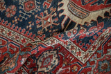 Textured wool pile showing geometric floral motifs on a folded antique Karaja rug.
