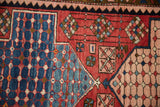 A detailed view of pinwheel and checkered floral motifs on a hand-knotted Baktiari rug.