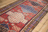 Angled view of the Baktiari runner's repeating seed design medallions and geometric borders.