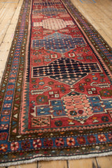 Long angled view down the vintage Baktiari runner's central column of repeating medallions.