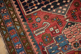 Close view of a boteh relief and checkered floral bouquets on a vintage Baktiari rug.