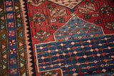 Detail of a vintage Baktiari runner's pinwheel border and blue interconnected seed design.