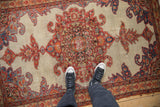 Overhead view of the antique Malayer rug highlighting its intricate medallion and even wear.