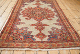 Angled perspective of an antique Malayer rug with its intricate red and blue central medallion.