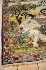 Kerman pictorial rug detail: bare feet, blush flowers, green foliage, ornate border, fringe.