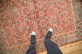 A view for scale showing the low-pile texture of the antique Heriz rug's Herati pattern.