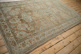 Distressed Mahal rug corner detail, highlighting faded powder blue floral patterns on brown.