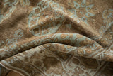 Close-up of distressed Mahal rug pile, showing faded powder blue patterns on oxidized brown.