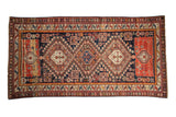 Antique Caucasian runner with three concentric medallions and serrated guls on a geometric navy blue field.