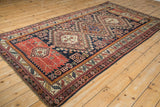 Angled perspective along the antique Caucasian rug's central column of medallions.