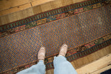 Overhead view showing the scale and colorful geometric lattice design of an antique Persian Serab runner rug.
