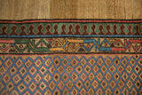 Detail of a Persian Serab rug's reciprocating pawn motif border and colorful lattice field.