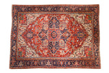 Vintage Heriz carpet with a bold geometric center medallion in cherry red and cobalt blue.
