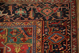 Corner detail of a vintage Heriz carpet's geometric Turtle Samovar border in navy, red, and green.