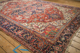 View across the geometric cherry red field and navy Turtle Samovar border of a vintage Heriz carpet.