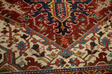 A close view of the Heriz carpet's knot heads and geometric arabesques in cherry red and cobalt blue.