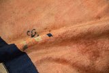 The time-softened dusty copper pile and visible knot heads of an antique Chinese rug.