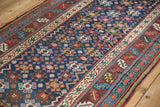 Intricate serrated leaf and meandering vine borders of a hand-knotted antique Persian runner.