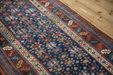 Angled view of an antique runner's geometric guls, meandering vine, and serrated leaf borders.