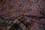 Dense, short pile of a vintage Kurd rug with blue and burgundy blossoming floral designs.