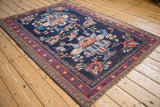 Vintage Afshar rug corner with red starburst border and ornate blue floral patterns.