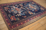 Vintage Afshar rug corner showing muted green outer border and red starburst pattern.